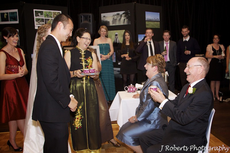 Chinese tea ceremony groom serving in laws - wedding photography sydney